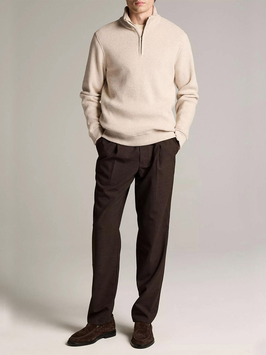 A man wears the Vince Brushed Cotton-Blend Waffle Quarter-Zip Pullover in Heather Oatmeal, paired with dark brown trousers and brown loafers against a plain light background.