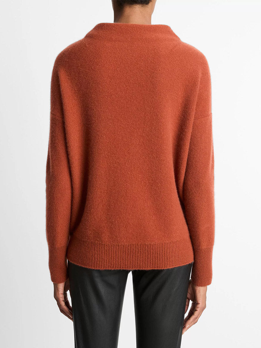 Person shown from the back against a plain white background, wearing a loose-fitting Vince Plush Cashmere Funnel-Neck Sweater in Tuscan Red and black pants.