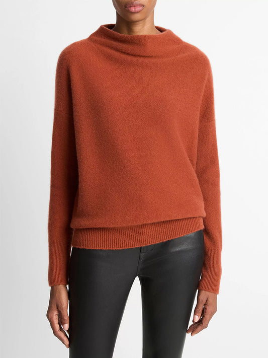 A person wears the Vince Plush Cashmere Funnel-Neck Sweater in Tuscan Red with black leather pants against a plain white background.