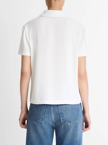 A person is shown from the back against a plain background, wearing blue jeans and the Vince Crepe Polo Shirt in off-white, featuring short sleeves and agoya shell buttons.