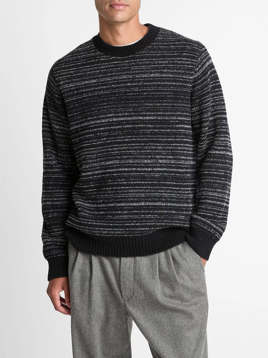 A person wears a Vince Marled Stripe Merino Wool-Blend Sweater in Black with gray trousers, standing against a plain white background.