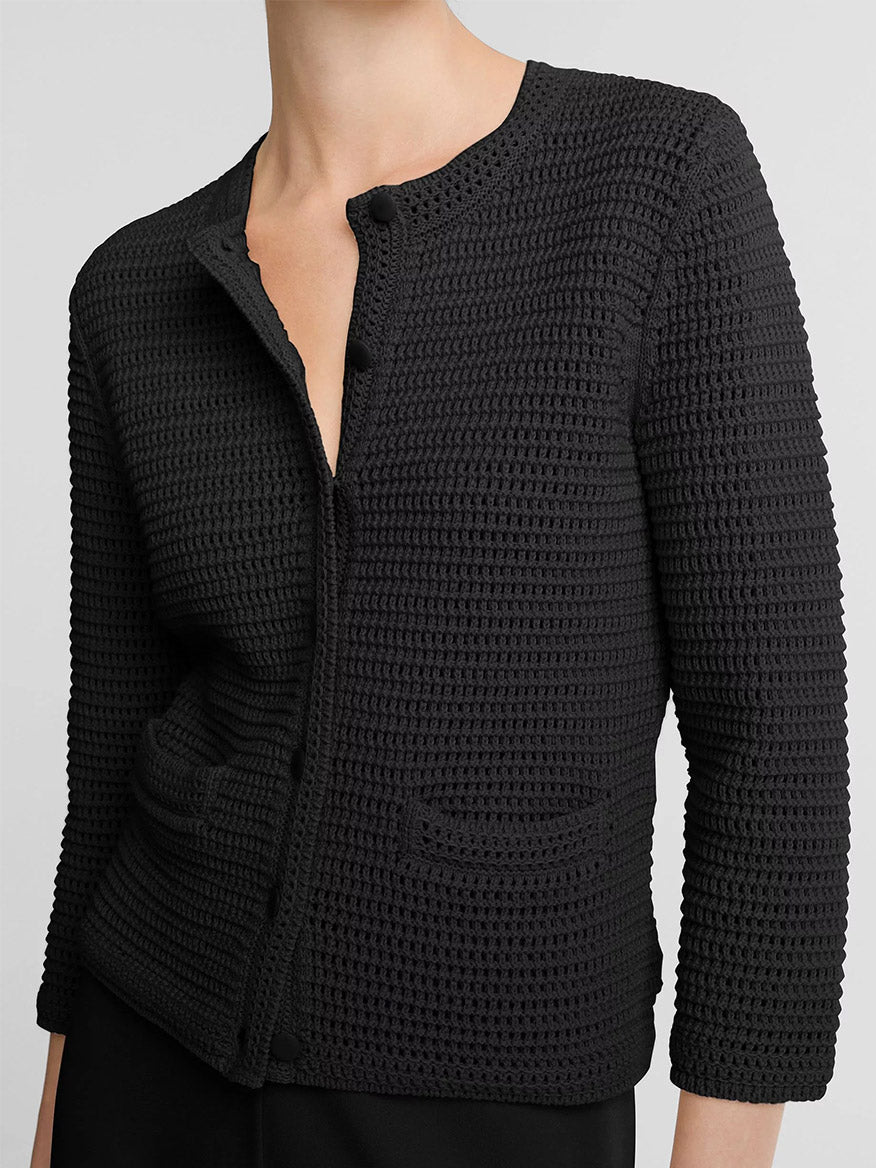 A person wears the Vince Italian Cotton Crochet Cardigan in Black, featuring two front pockets and three-quarter sleeves—ideal for spring-summer layering.