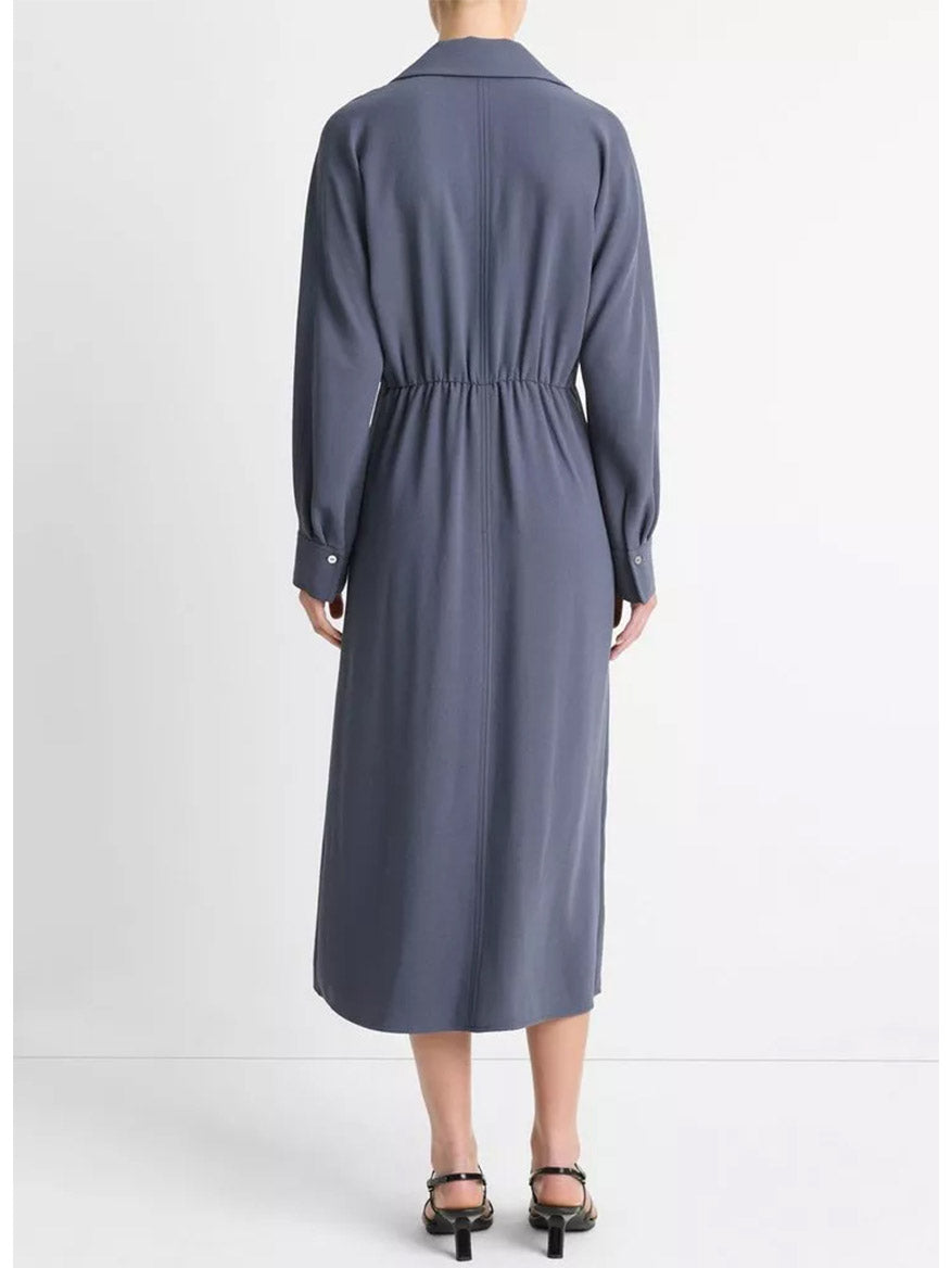 Back view of a person wearing the Vince Shaped Collar Dolman-Sleeve Dress in Dark Water with an elasticized waist and black sandals against a plain white background.