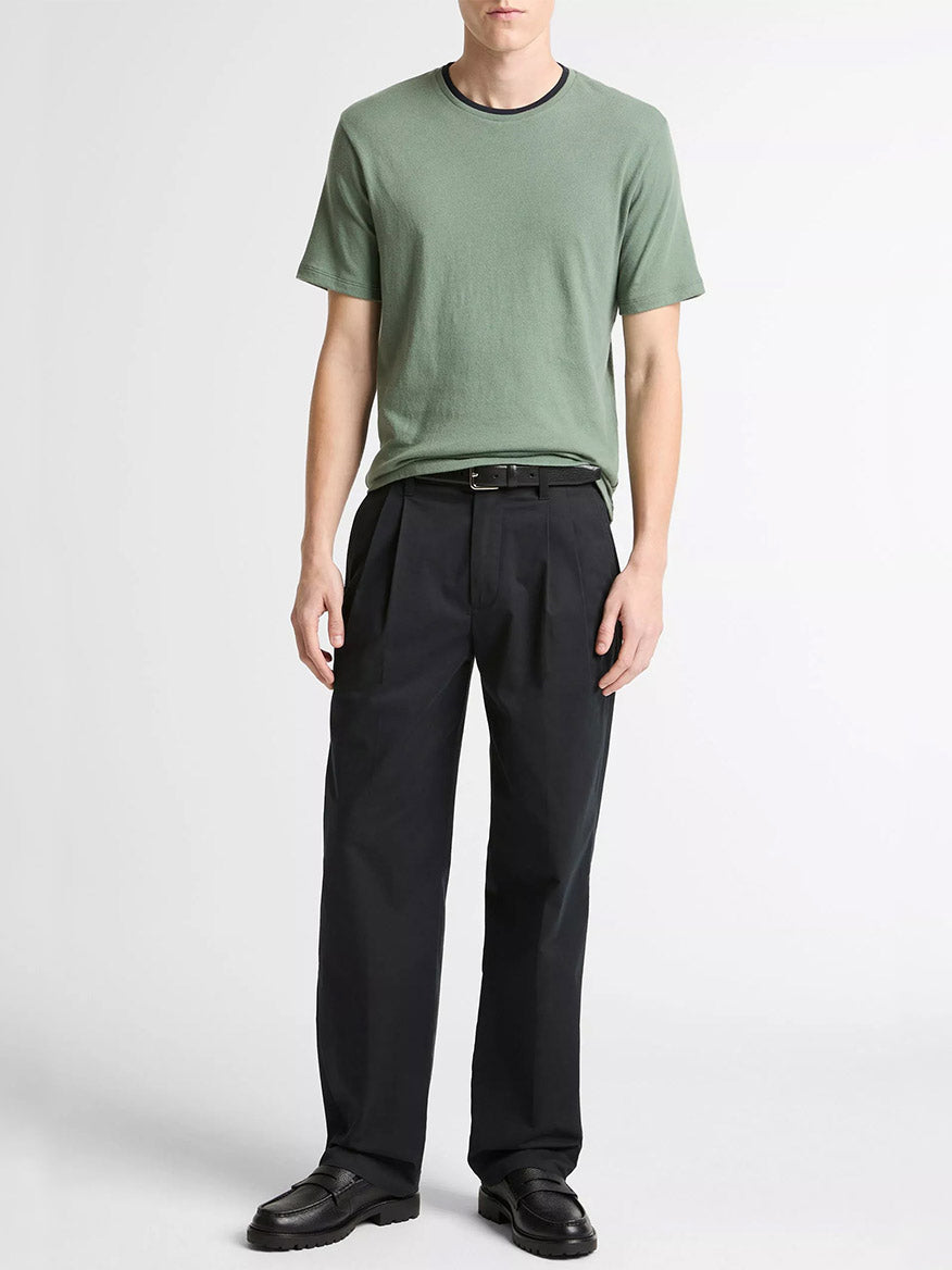 A person wearing the Vince Cotton Double-Collar T-Shirt in Laurel/Coastal Blue, black pleated trousers, and black shoes stands against a plain white background.