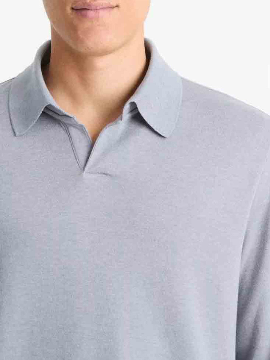 A person wearing a Vince Double Face Long Sleeve Polo Shirt in Blue Spruce/Light Grey is shown from the chest up against a plain white background.