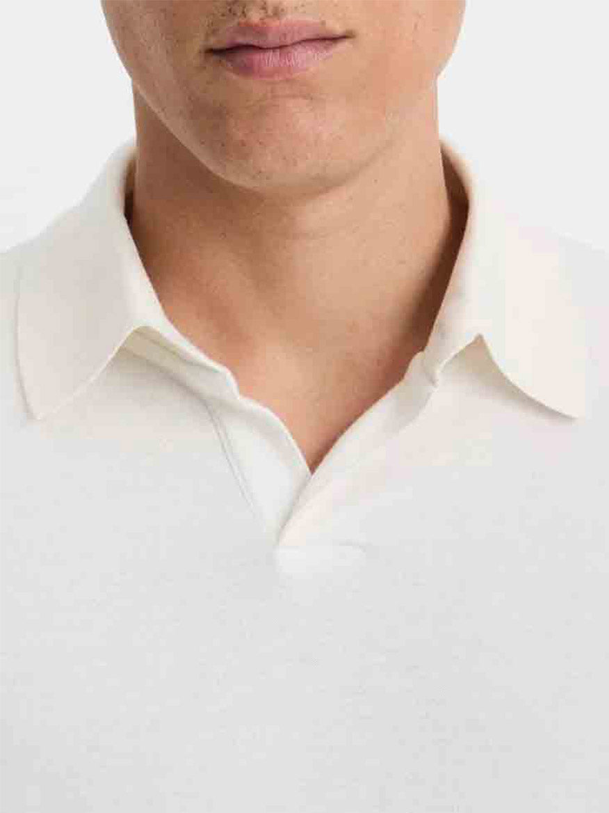 A person wearing a Vince Double Face Long Sleeve Polo Shirt in Cream/Optic White, with the image centered on their upper torso and mouth, against a plain background.