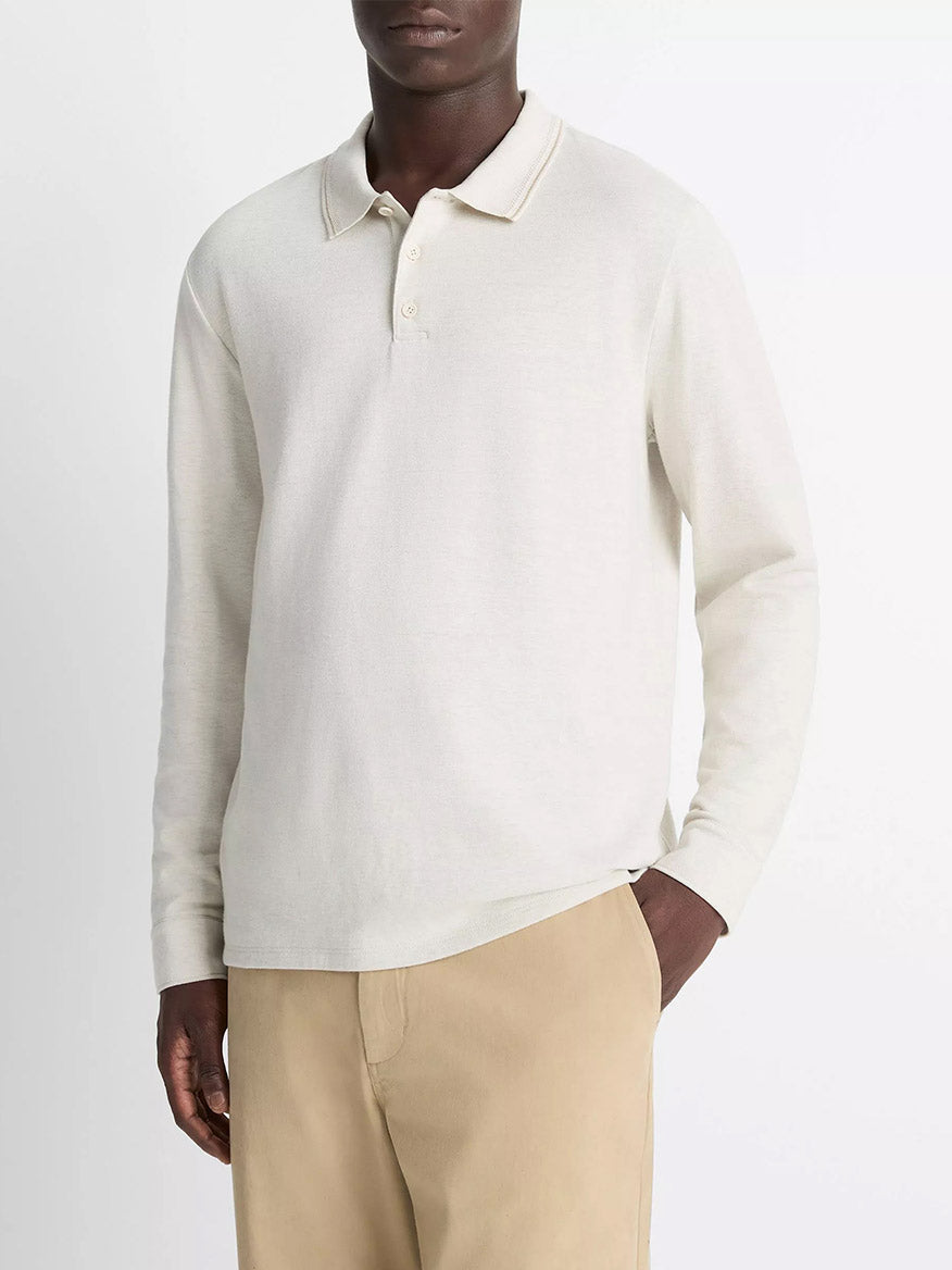 A person wears the Vince Heathered Double-Face Cotton-Blend Polo Shirt in Heather Blanco/Terrapin with tan pants, standing against a plain white background.