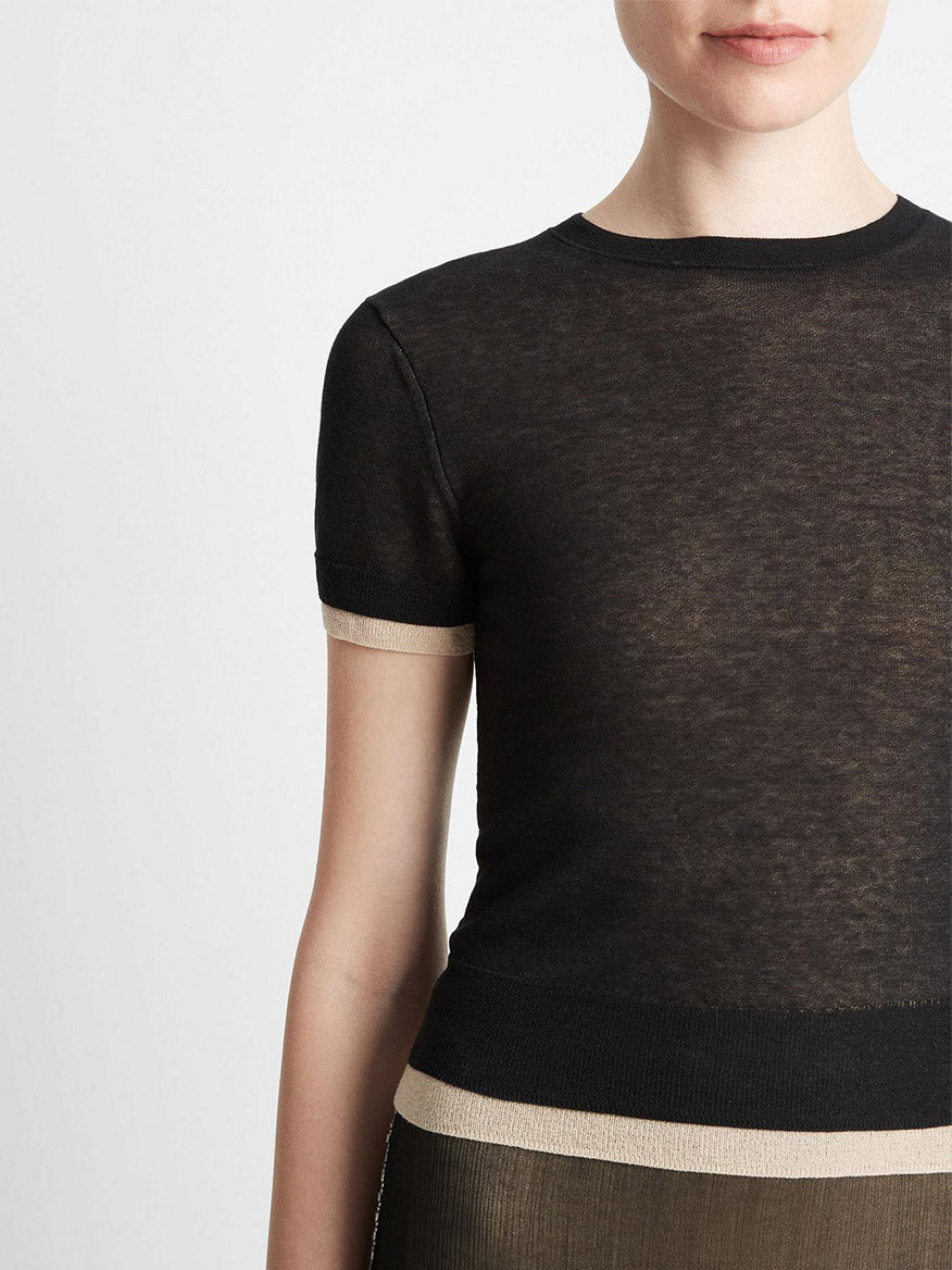 Close-up of a woman wearing a Vince Double Layer Knit T-Shirt in Black/Oat Sand Combo, crafted from an Italian cotton blend.