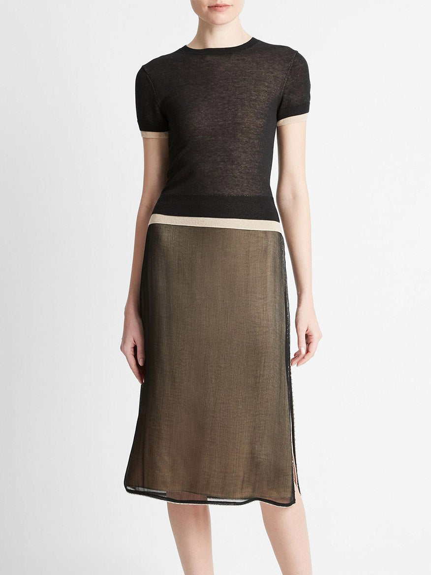 A mannequin dressed in a Vince Double Layer Knit T-Shirt in Black/Oat Sand Combo and a brown midi skirt with a white horizontal stripe and sheer overlay.