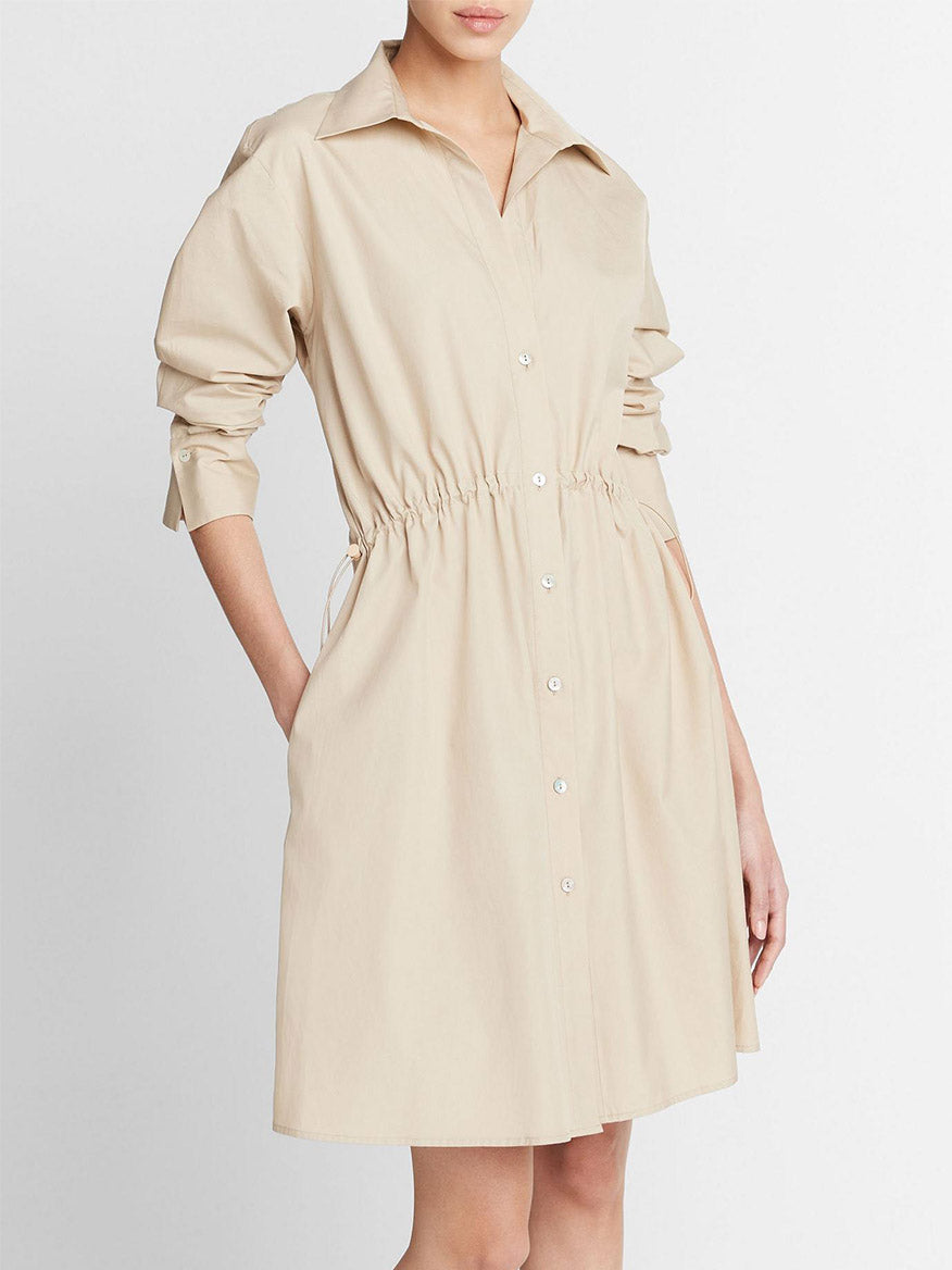 A woman in a Vince Cotton Drawcord Ruched Shirt Dress in White Oak, standing against a plain background.