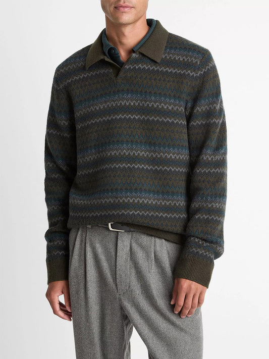 A man wearing the Vince Fair Isle Wool-Cashmere Johnny-Collar Sweater in Dark Leaf Combo, paired with grey trousers and a black belt, stands against a plain white background.
