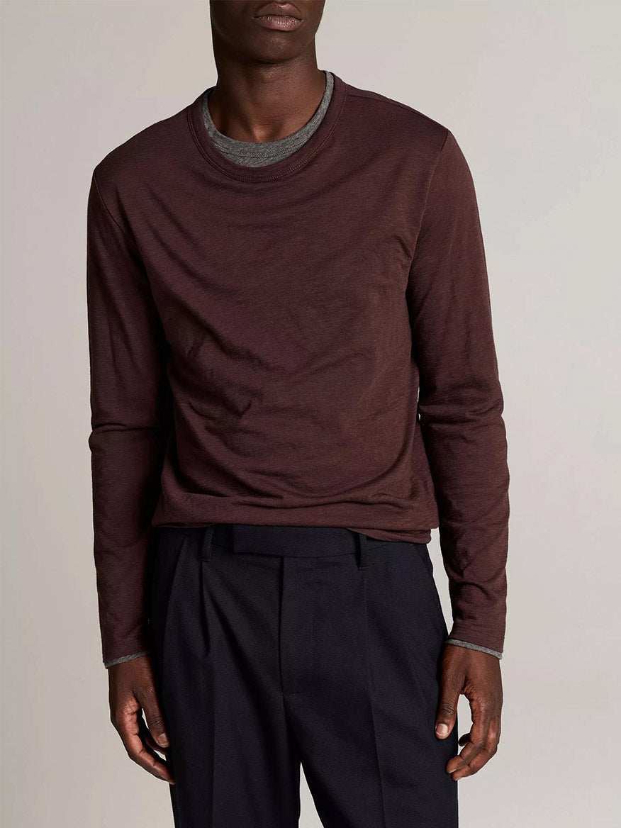 A person wearing the Vince Slub Pima Cotton Double-Layer T-Shirt in Chocolate Plum/Medium Heather Grey with black pleated trousers, standing against a plain background.