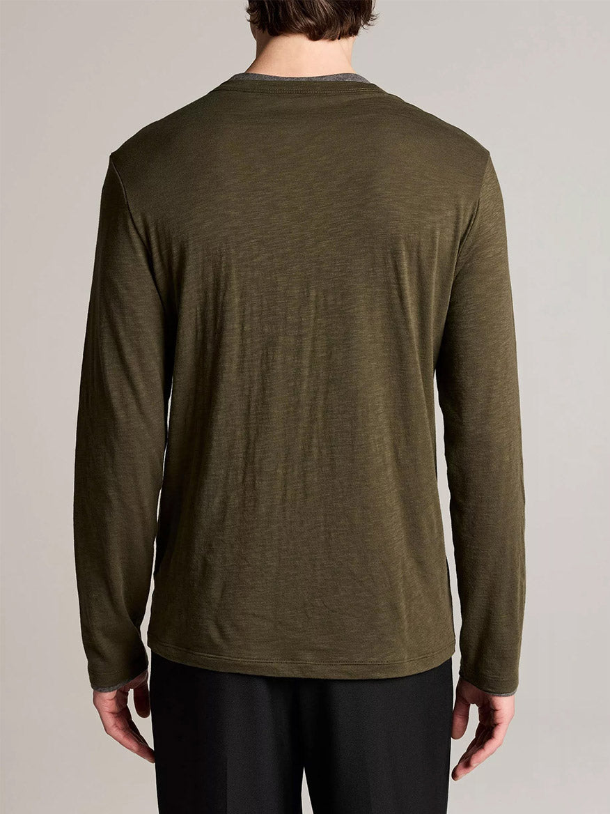 A person wearing the Vince Slub Pima Cotton Double-Layer T-Shirt in Night Leaf/Medium Heather Grey and black pants stands facing away, showcasing easy layering.