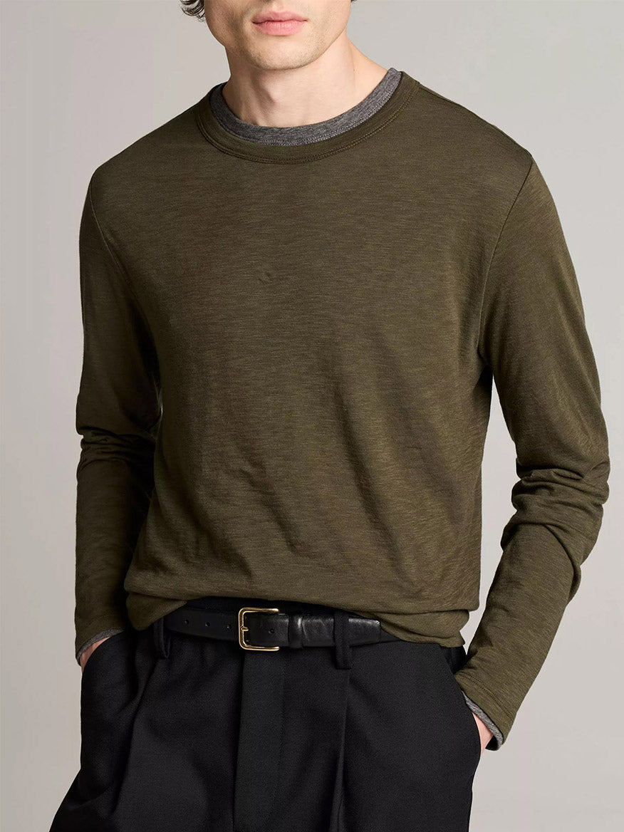 A person wears the Vince Slub Pima Cotton Double-Layer T-Shirt in Night Leaf/Medium Heather Grey, tucked into black pants with a black belt.
