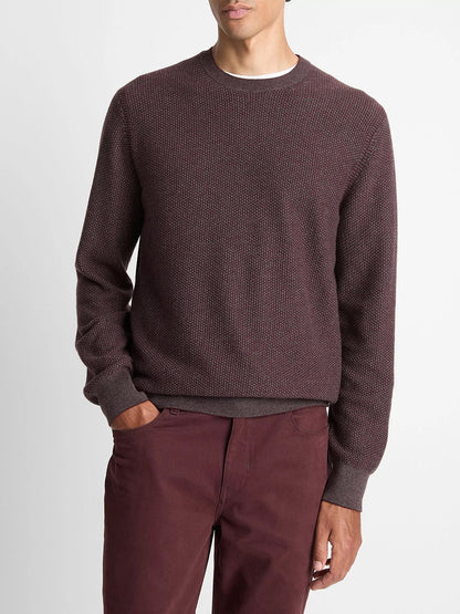 A man stands with one hand in his pocket, wearing the Vince Geo-Jacquard Wool-Blend Crew Neck Sweater in Port/Medium Heather Grey against a plain background.