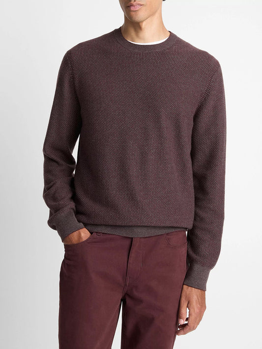 A man stands with one hand in his pocket, wearing the Vince Geo-Jacquard Wool-Blend Crew Neck Sweater in Port/Medium Heather Grey against a plain background.