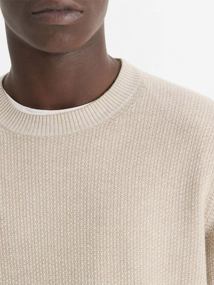 A person wearing the Vince Geo-Jacquard Wool-Blend Crew Neck Sweater in British Khaki/Classic Cream layered over a white shirt. The photo showcases the lower half of their face and upper chest against a simple backdrop.