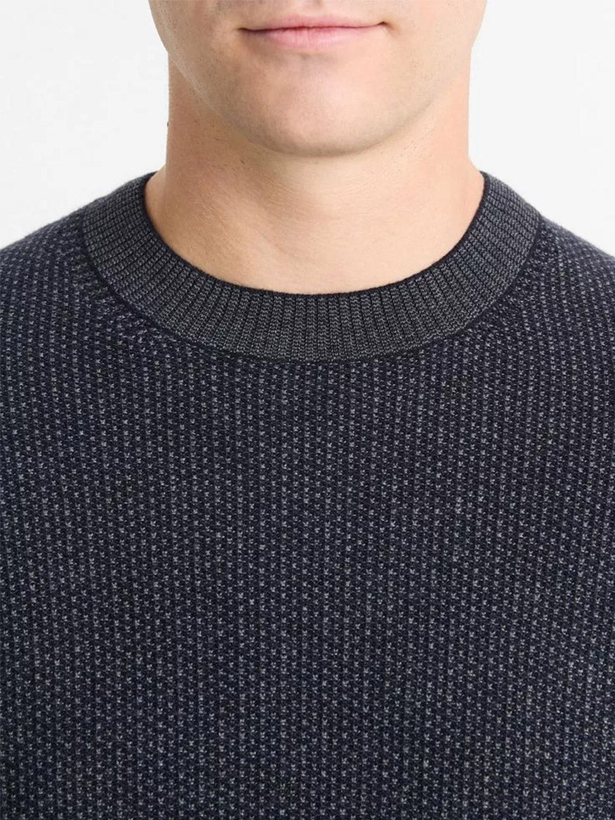 A person is wearing a medium gray, wool-blend crew neck sweater by Vince, visible from the chin to the chest.