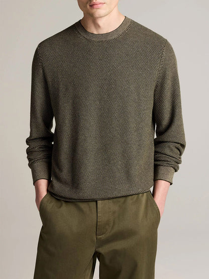 A man stands with his hands in his pockets against a plain background, wearing the Vince Geo-Jacquard Wool-Blend Crew Neck Sweater in Midnight Garden/River Sand, paired with matching pants.