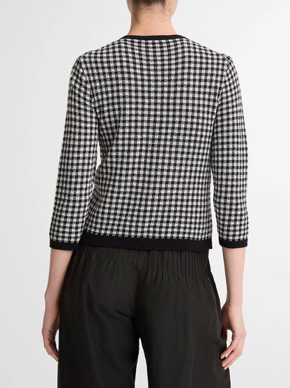 A person is shown from behind, wearing the Vince Gingham Italian Wool Blend Cardigan in Black/Off-White with three-quarter sleeves and black pants. Its wool-cotton blend offers transitional weight comfort, set against a plain backdrop.