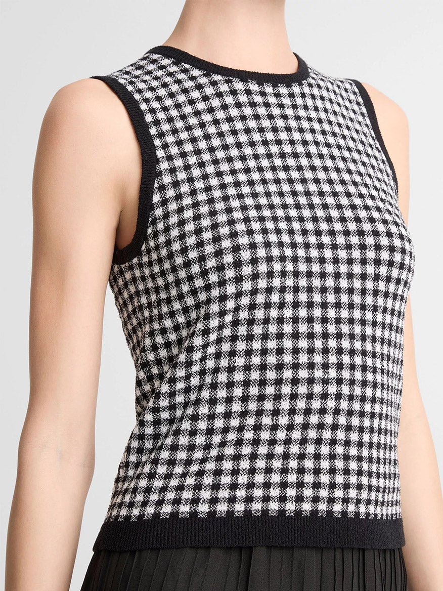 Person wearing the Vince Gingham Italian Wool Blend Shell in Black/Off-White, a sleeveless knit top crafted from a transitional weight wool-cotton blend, featuring black trim on the collar and armholes.