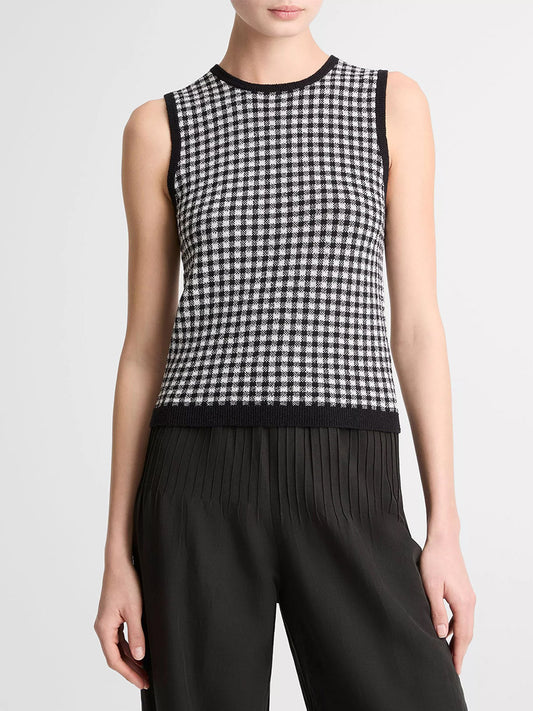 A person wears the Vince Gingham Italian Wool Blend Shell in Black/Off-White, a sleeveless knit top, paired with high-waisted black pleated pants.