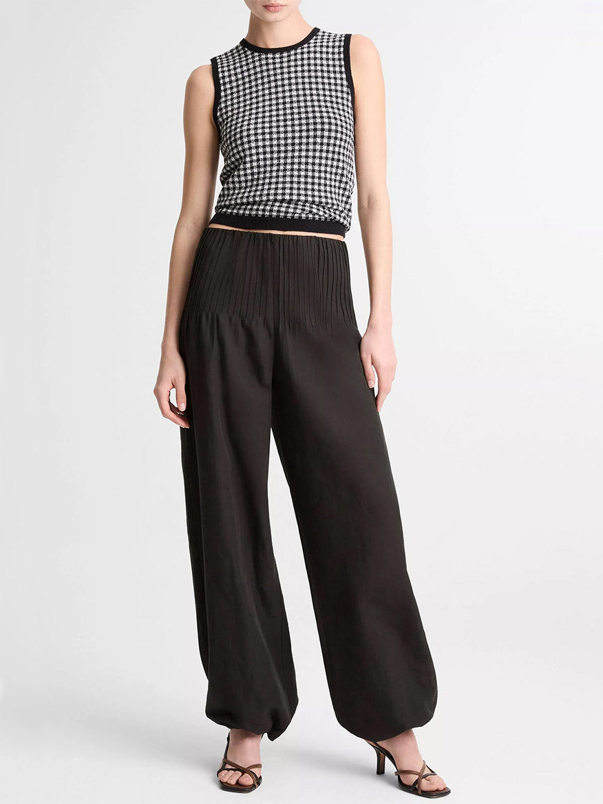 A person wearing the Vince Gingham Italian Wool Blend Shell in Black/Off-White, wide-leg black pleated wool-cotton pants, and black heeled sandals stands against a plain white background.