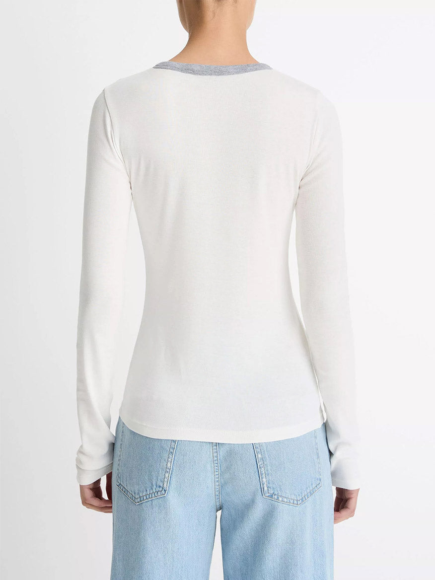 A person wearing the Vince Tipped Heathered Pima Cotton-Blend Long-Sleeve T-Shirt in Off White Combo and light blue jeans, shown from the back against a plain white background.