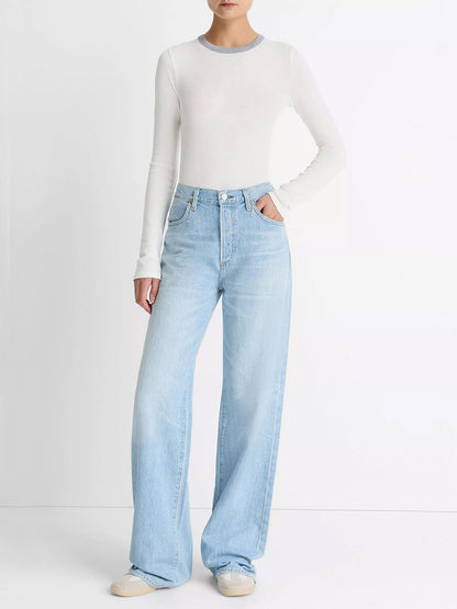 A person wears the Vince Tipped Heathered Pima Cotton-Blend Long-Sleeve T-Shirt in Off White Combo, paired with light blue high-waisted wide-leg jeans and white shoes, standing against a plain white background.