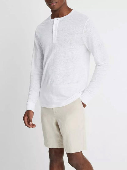 Man wearing a Vince Linen Long Sleeve Henley in Optic White paired with beige shorts.