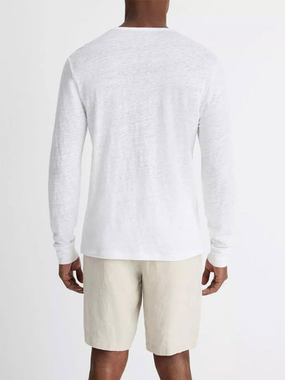 A man seen from the back wearing a Vince Linen Long Sleeve Henley in Optic White and beige shorts.
