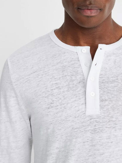 Close-up of a man wearing a Vince Linen Long Sleeve Henley in Optic White with white buttons.
