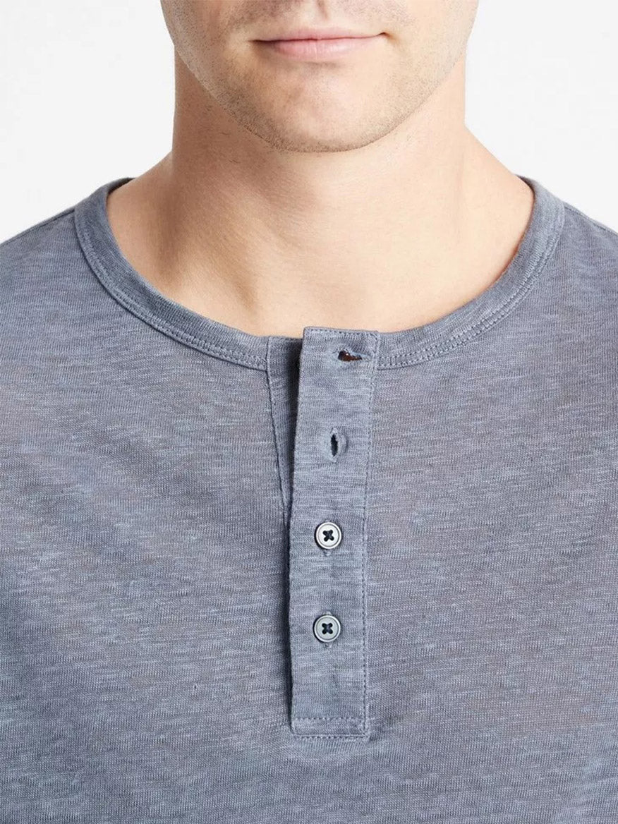 Close-up of a man wearing a lightweight, breathable Vince Linen Long Sleeve Henley in Washed Indigo with buttons.