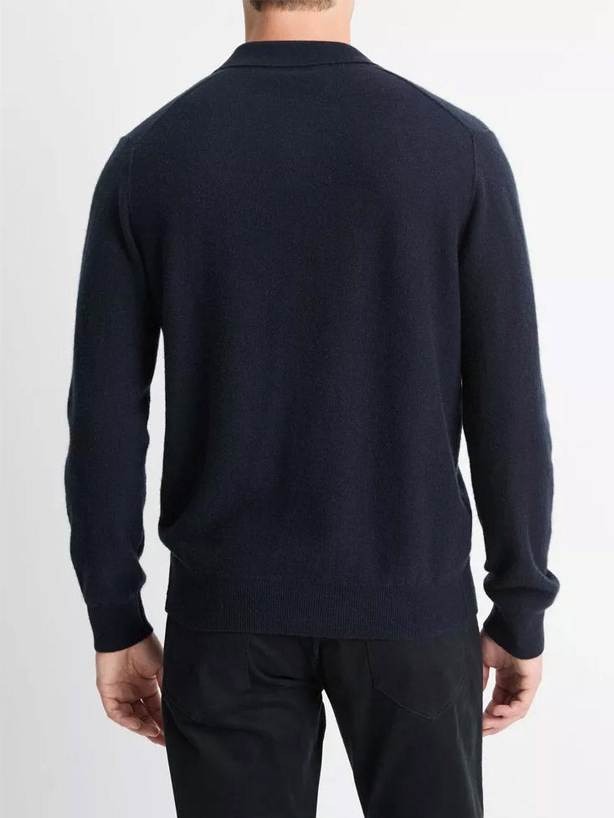 A person wearing the Vince Plush Cashmere Johnny-Collar Polo in Coastal paired with black pants is viewed from the back against a light background.