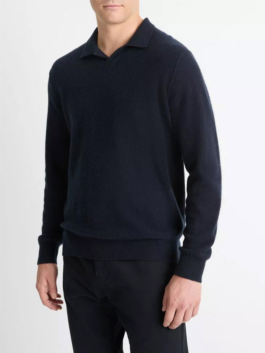 A person stands against a plain backdrop wearing the Vince Plush Cashmere Johnny-Collar Polo in Coastal and pants.