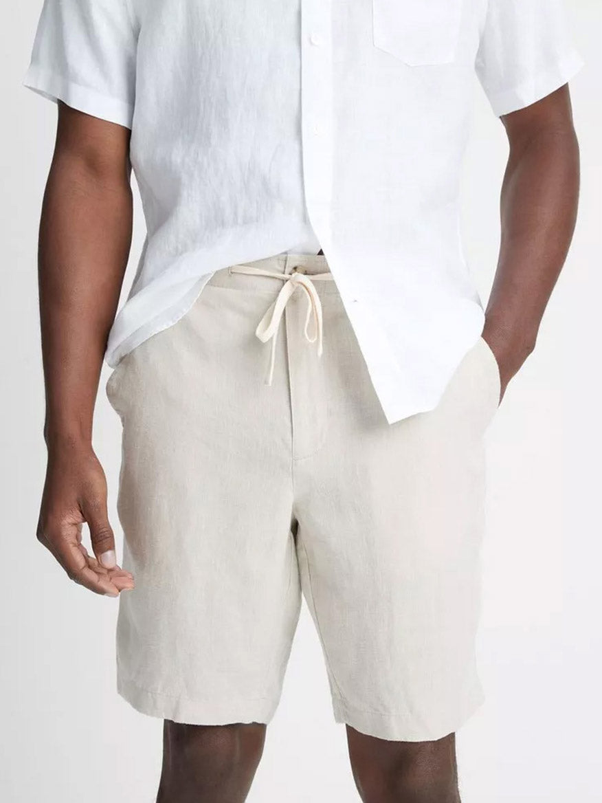 Man wearing a white shirt and beige Vince Lightweight Hemp Short in Pumice Rock with drawstring closure.