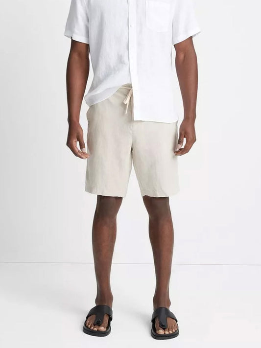 Man wearing a white short-sleeved shirt, Vince Lightweight Hemp Short in Pumice Rock with drawstring closure, and black sandals.