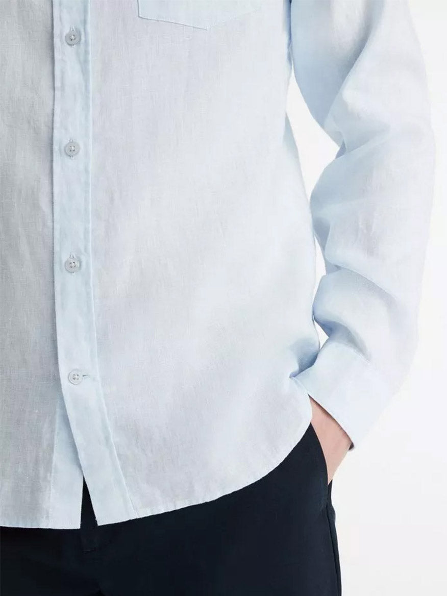 Person wearing a Vince Linen Long Sleeve Shirt in Glacier, tucked into dark trousers.