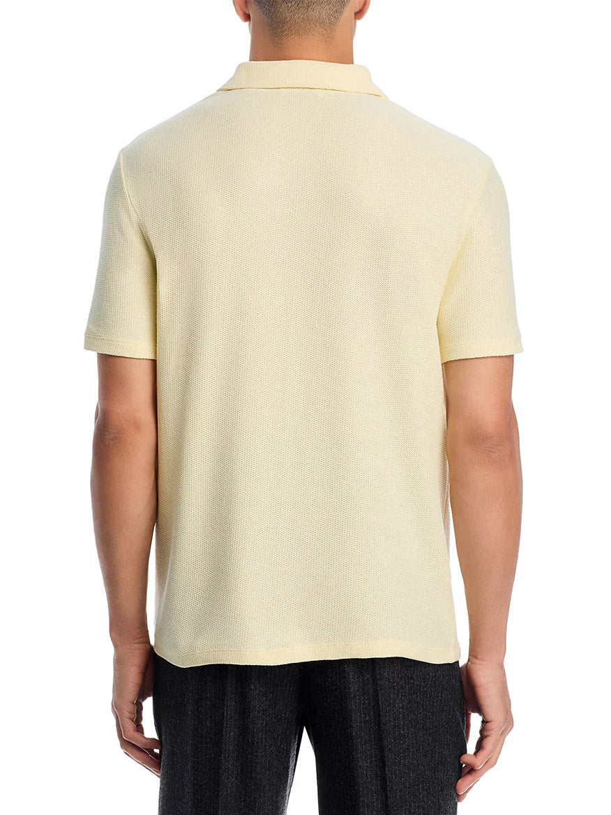 A person is seen from the back against a white background, wearing the Vince Macro Honeycomb Cabana Johnny Collar Shirt in Cream with dark pants.