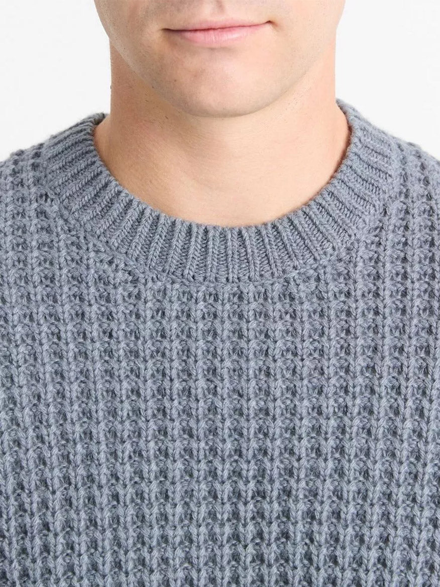 A person wearing the Vince Macro-Waffle Crew Neck Sweater in Evening Mist. Only the lower part of the face and upper torso are visible, showcasing this classic essential with its subtly defined crew neck.