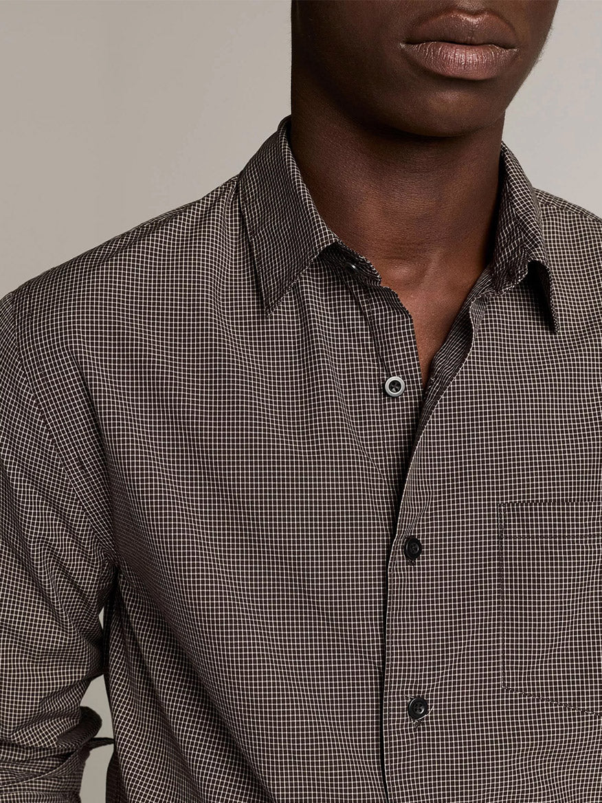 A person wearing the Vince McDermott Plaid Cotton Button-Front Shirt in Arabica/Headline Grey, featuring a chest pocket and a brown and black windowpane check pattern, shown from the chest up against a plain background.
