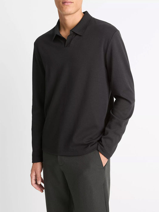 A man wears the Vince Milano Pima Cotton-Blend Johnny-Collar Shirt in black with dark pants, standing against a plain white background.
