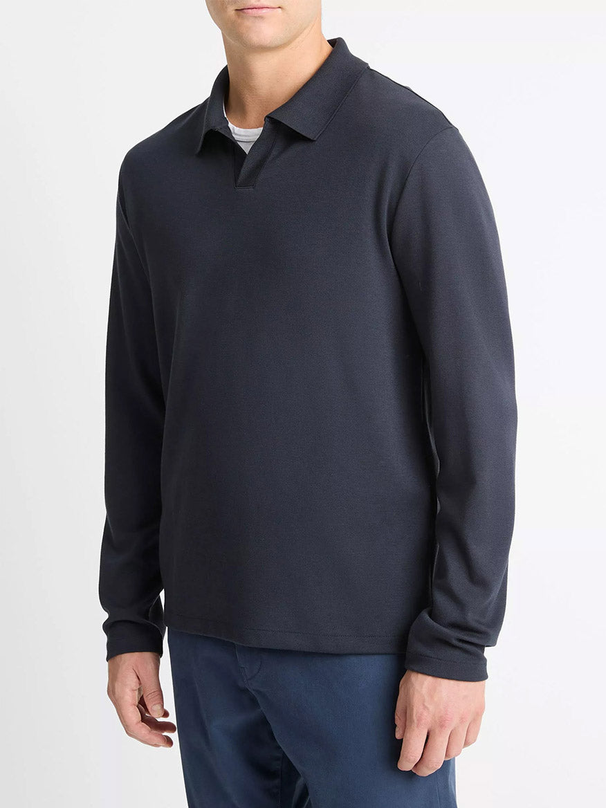 A man wearing the Vince Milano Pima Cotton-Blend Johnny-Collar Shirt in Coastal Blue and blue pants, standing against a plain white background.