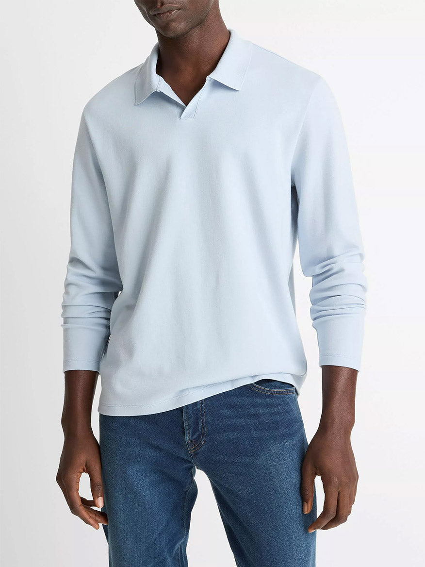 A person wearing the Vince Milano Pima Cotton-Blend Johnny-Collar Shirt in Whitecap and blue jeans stands against a plain white background.