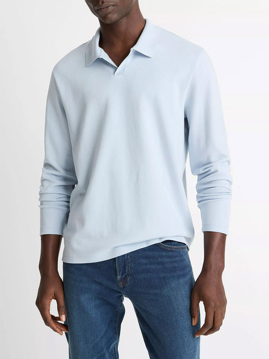 A person wearing the Vince Milano Pima Cotton-Blend Johnny-Collar Shirt in Whitecap and blue jeans stands against a plain white background.