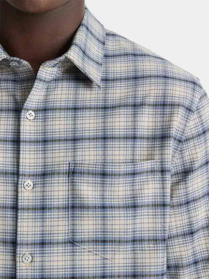 Close-up of a person wearing the Vince Oceanic Plaid Shirt in Bright Beluga Blue/Taupe, crafted in a lightweight weave with a front pocket, set against a plain white background.