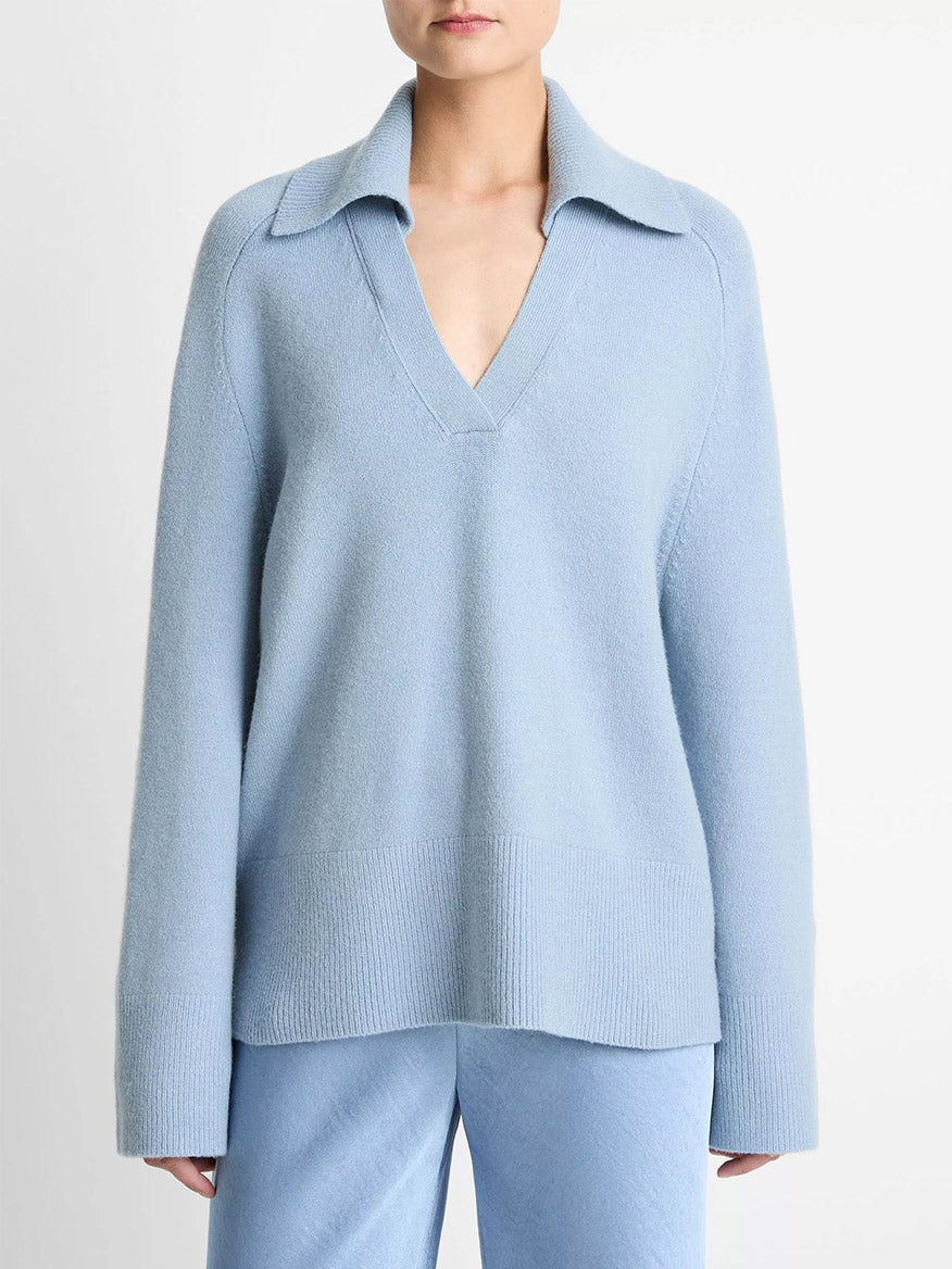 Model wears the Vince Wool & Cashmere-Blend Oversized Polo Sweater in Pacific with matching light blue pants, styled against a plain white background.