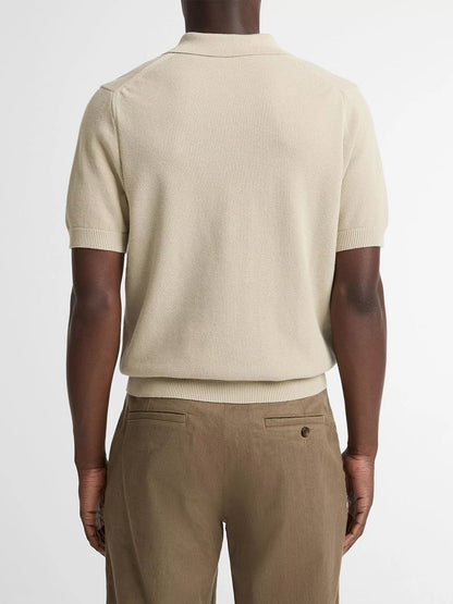 A person seen from the back wears the Vince Cotton-Cashmere Piqué Zip Polo Sweater in Parchment with light brown trousers, standing against a plain background.