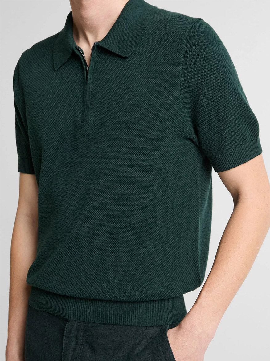 Person wearing the Vince Cotton-Cashmere Piqué Zip Polo Sweater in Seaweed and dark pants, shown from neck to waist against a plain background.