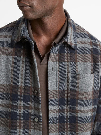 A person wears the Vince Plaid Cotton-Blend Shirt Jacket in Medium Heather Grey Combo over a brown collared shirt, with only their lower face, neck, and upper torso visible.